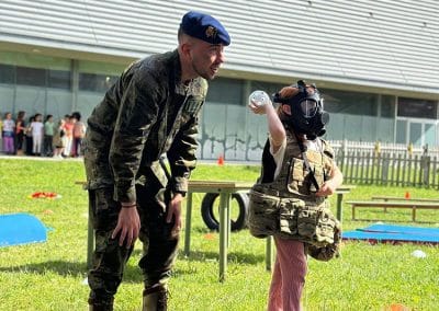 Una niña, acompañada de un guardia real, disfruta con una de las actividades organizadas por el Grupo de Honores