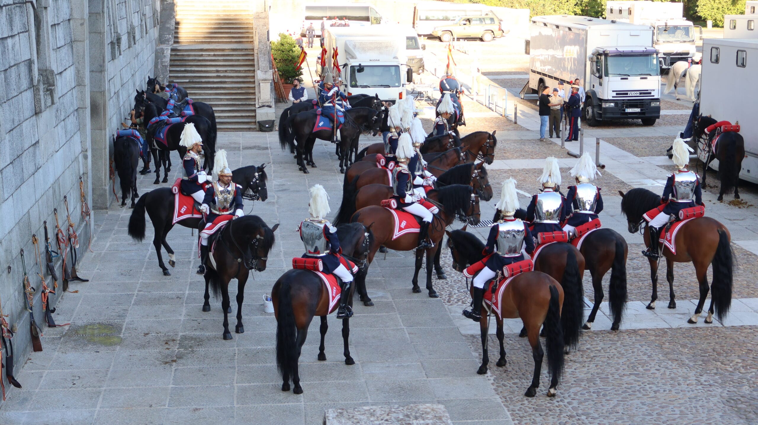Guardias reales a caballo reunidos en un patio, con coraceros y lanceros del Escuadrón de Escolta Real.